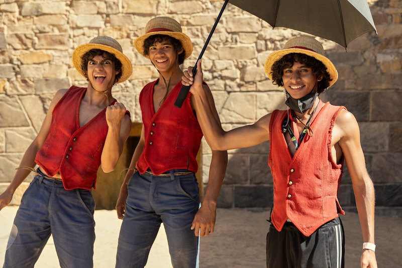 Iñaki Godoy as Monkey D. Luffy and stunt double Cameron Groep pose together with another stunt double dressed as Luffy in Season 1 of 'One Piece.'