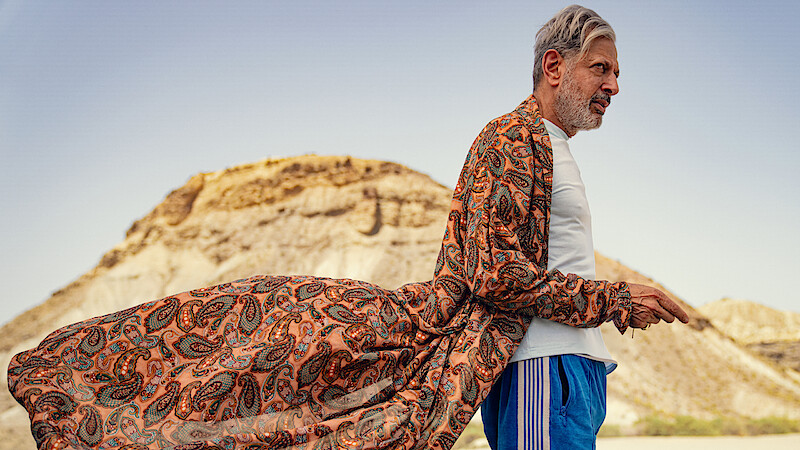 Jeff Goldblum as Zeus stands near a mountain wearing a long flowing robe and track pants in Season 1 of Kaos