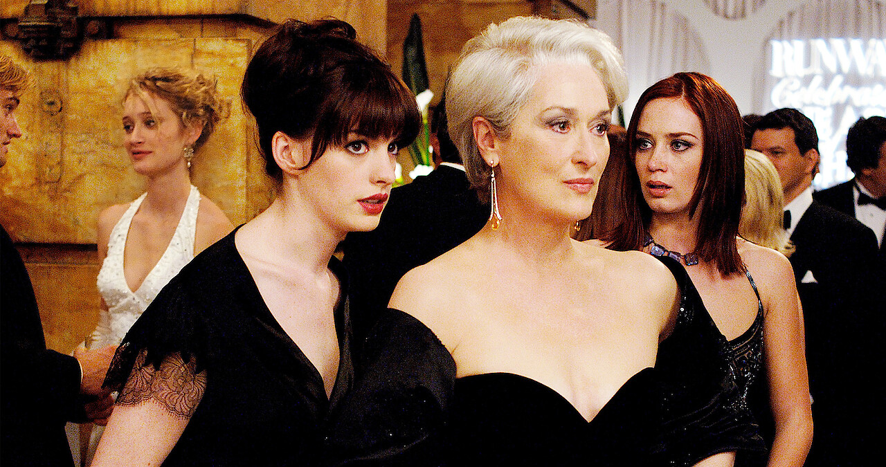 Anna Hathaway, Meryl Streep, and Emily Blunt in a party scene in 'The Devil Wears Prada.' 