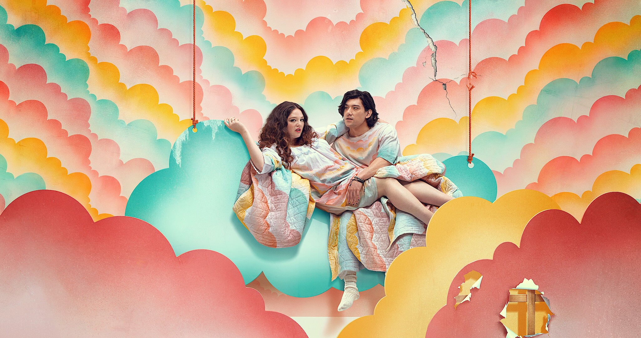 Too Much - the cast sitting on a floating pink, purple and yellow cloud