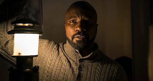 Mike Coulter as David Acosta in Season 2 of 'Evil' holding a lantern.