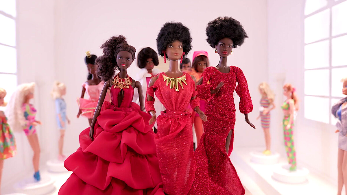 Black Barbie dolls posed together.