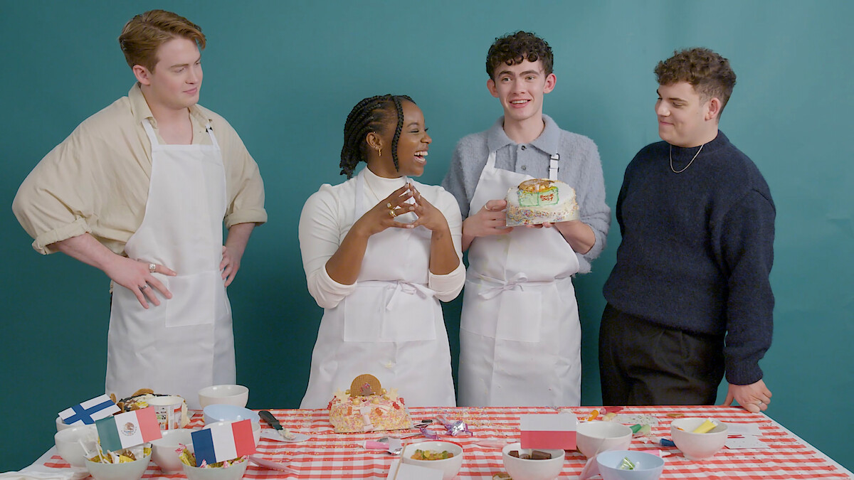 Kit Connor, Corinna Brown, Joe Locke, and Tobie Donovan smile while decorating cakes 