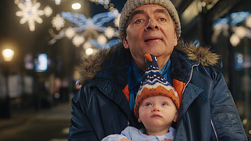 Rowan Atkinson as Trevor Bingley holds a baby in 'Man vs. Baby.'