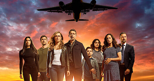 The cast of Manifest stand with an airplane taking flight behind them