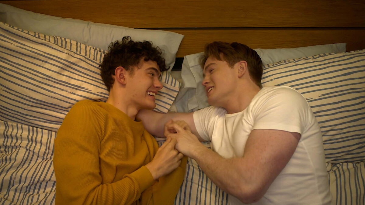 Joe Locke as Charle and Kit Connor as Nick cuddle together in bed in Season 3 of 'Heartstopper.'