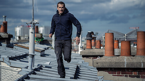 Guillaume Canet runs on a rooftop in the film 'Ad Vitam.'