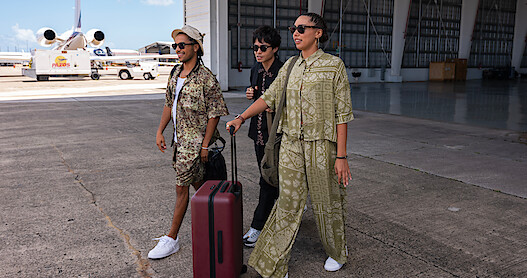 Tyler Dean Flores as Santi, Jordan Mendoza as Felix, and Emma Ferreira as Ness walk through a private airport in Season 1 of 'Neon.'