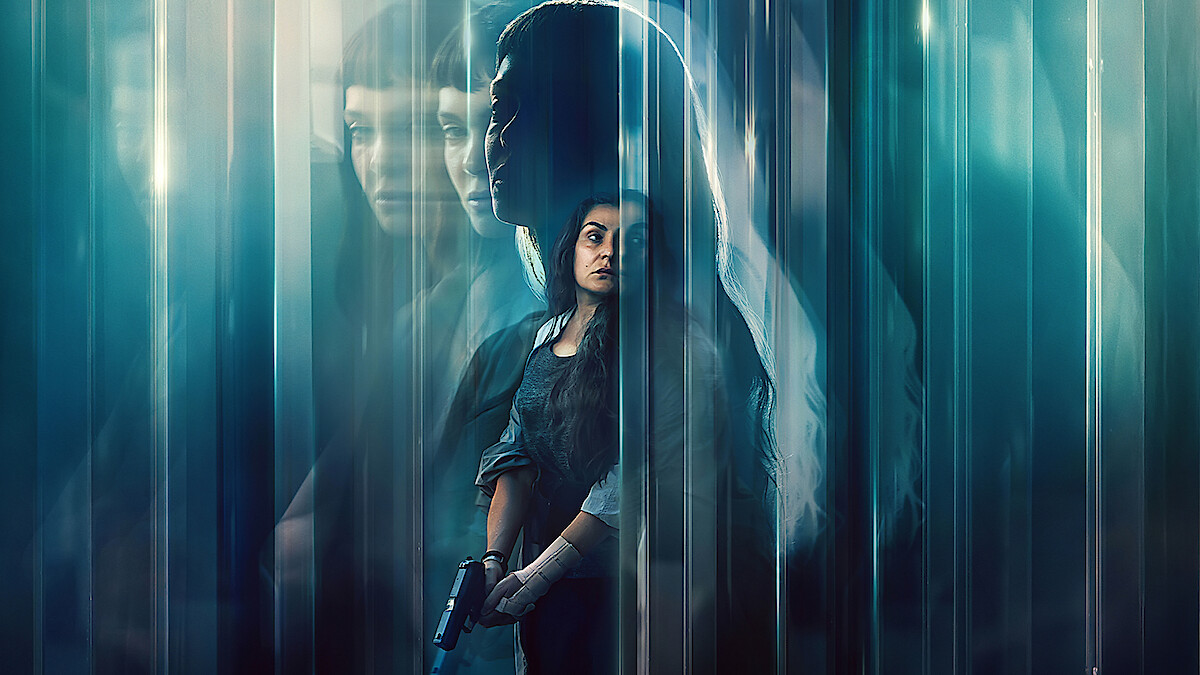 A woman holding a gun stands in a dark, mysterious environment with blue tones and blurred, ghostly reflections of herself and another woman, creating a suspenseful and intense atmosphere.