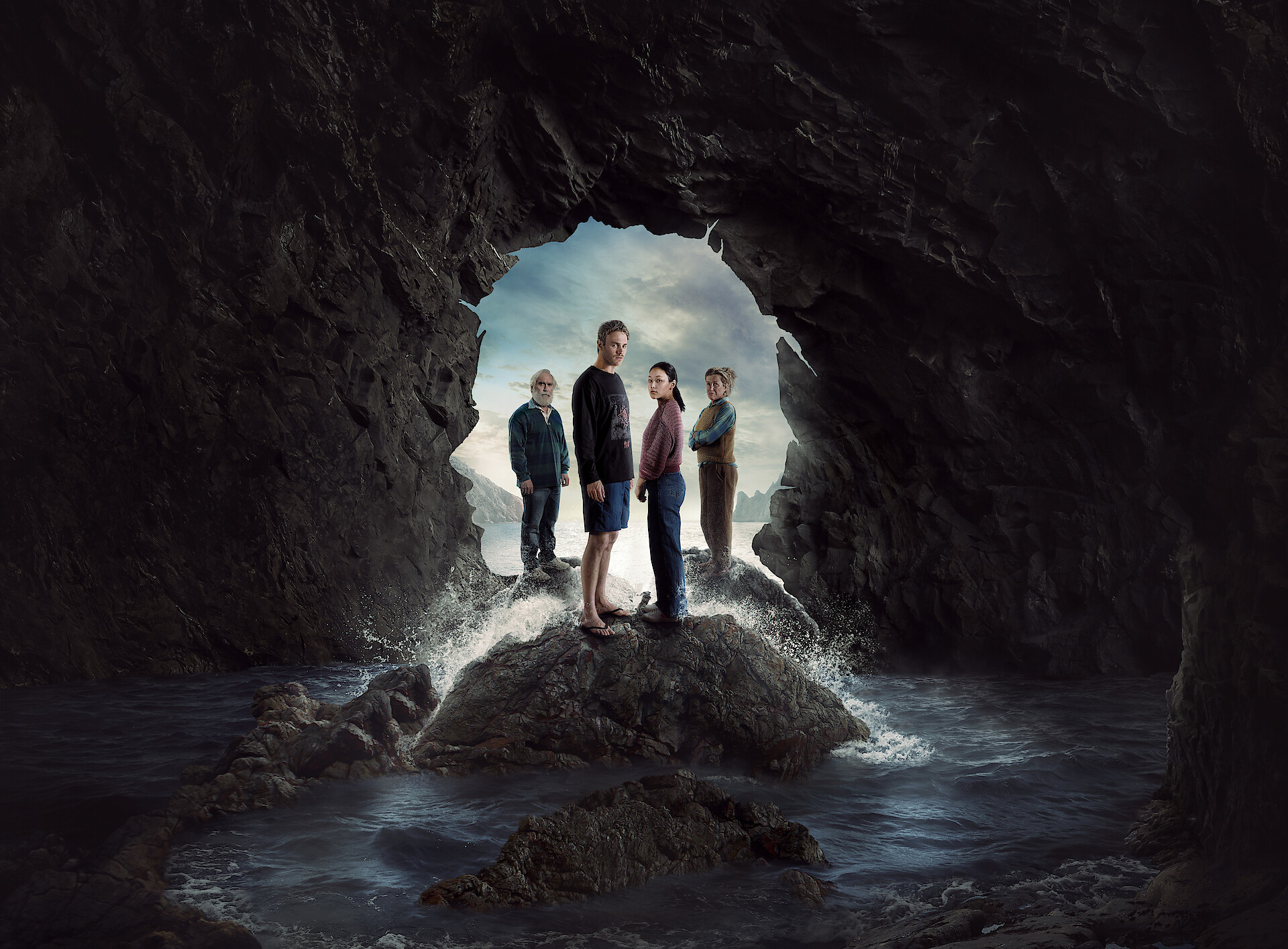 The Survivors - The cast standing at the entrance to a mysterious cave. 