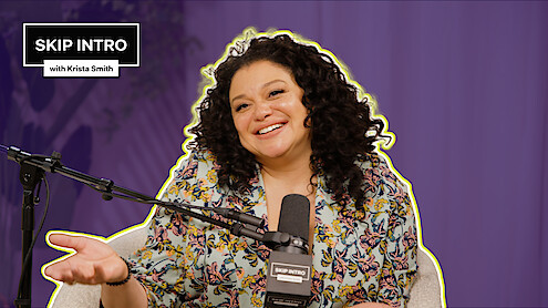 Michelle Buteau smiles and sits in front of a microphone, wearing a floral top. The background is purple, and there's a text box saying "SKIP INTRO with Krista Smith" in the top left corner.
