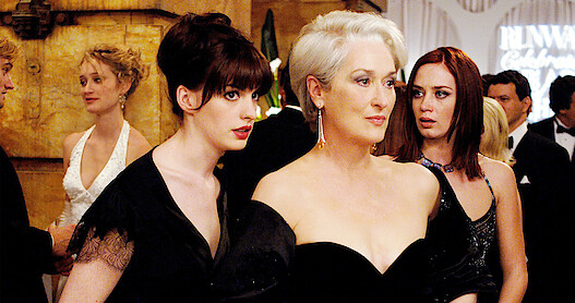 Anna Hathaway, Meryl Streep, and Emily Blunt in a party scene in 'The Devil Wears Prada.' 