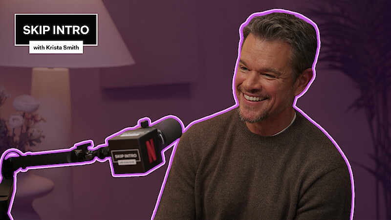 Matt Damon sits smiling in front of a microphone during a podcast recording for "Skip Intro with Krista Smith." The background is purple, and the podcast logo appears in the top left corner.