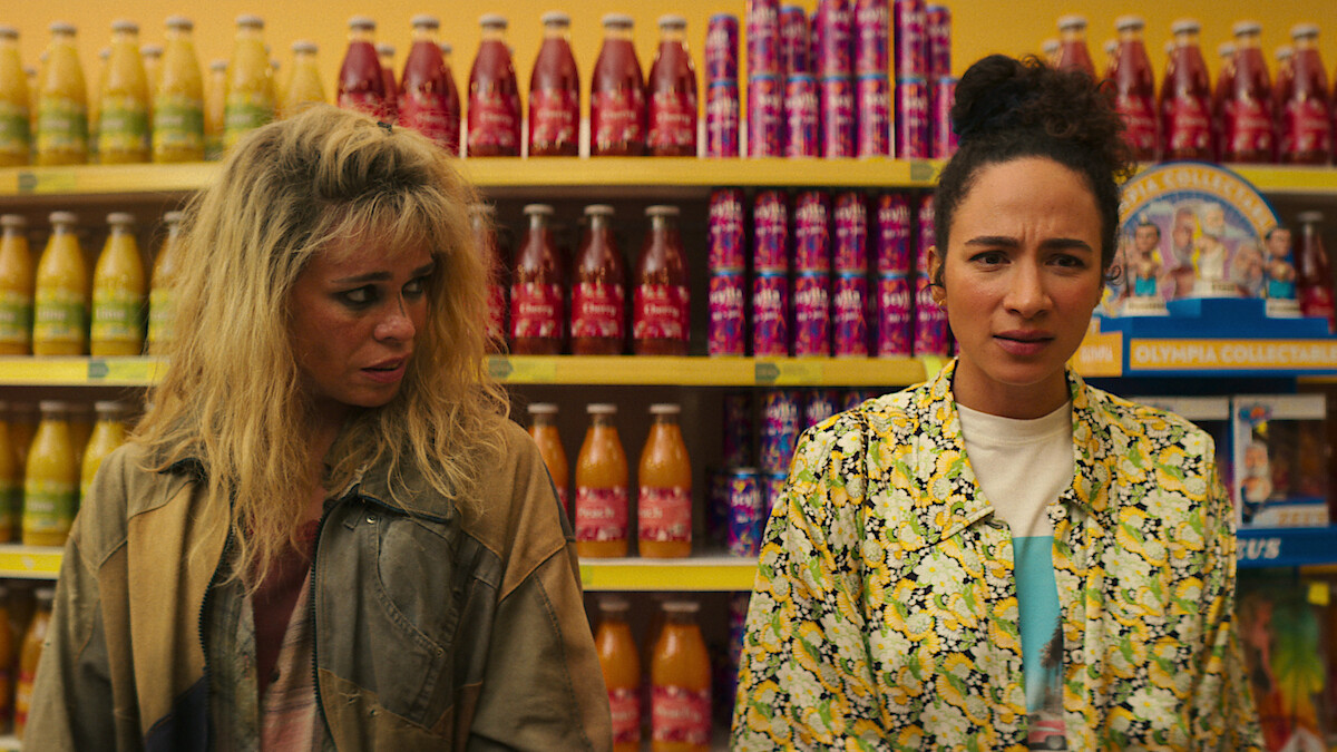Riddy stands in a grocery store aisle in Season 1 of 'KAOS'
