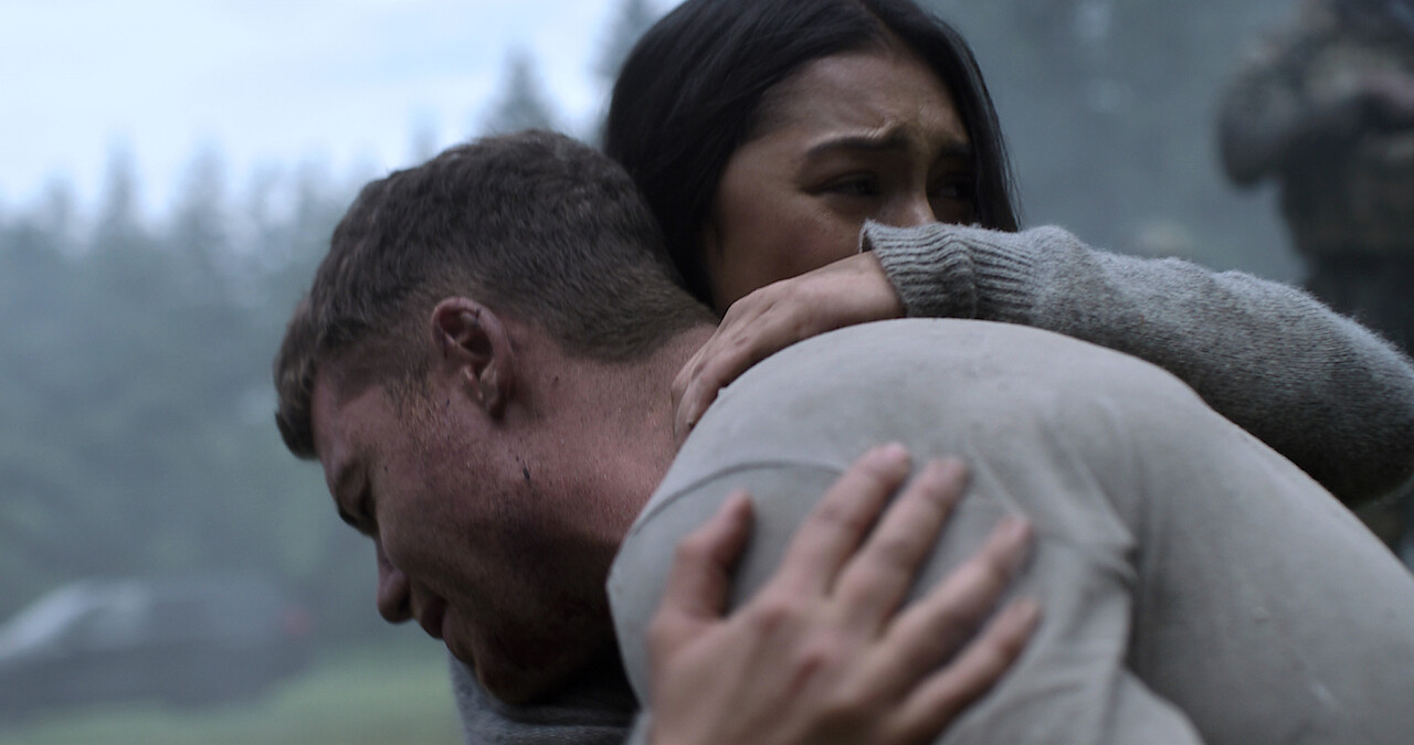 Gabriel Basso as Peter Sutherland and Luciane Buchanan as Rose hug on The Night Agent