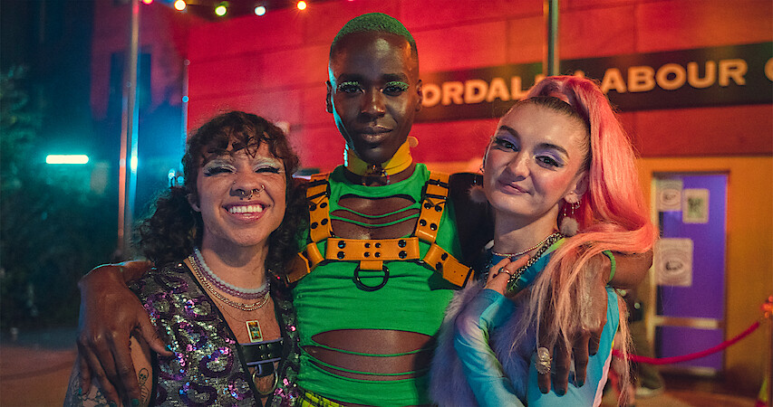 Felix Mufti as Roman, Ncuti Gatwa as Eric, and Anthony Lexa as Abbi stand together at a club in Season 4 of 'Sex Education.'