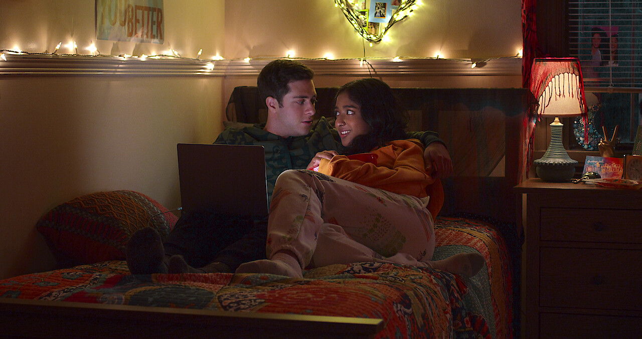 Jaren Lewison as Ben Gross and Maitreyi Ramakrishnan as Devi in Never Have I Ever Season 4 sitting on college dorm bed.