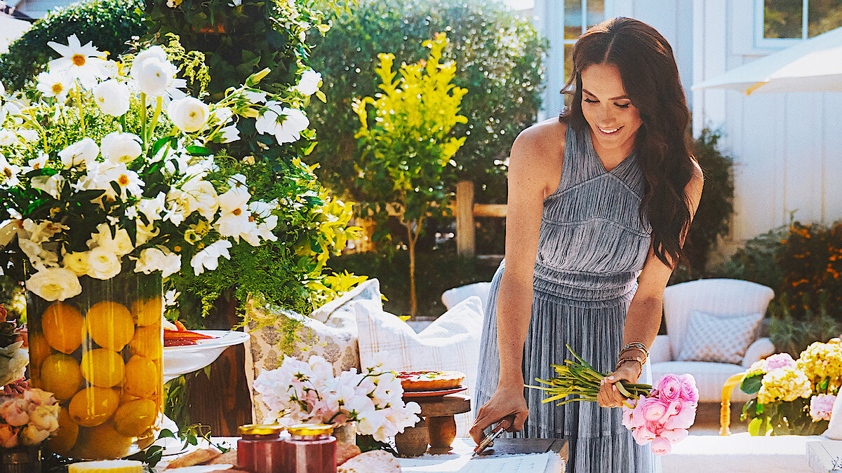 Meghan cuts a bouquet of flowers outside.