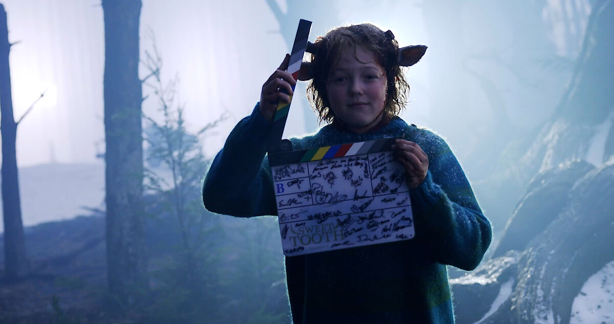 Christian Convrey as Gus holds a clap board in this behind the scenes shot from Season 3 of 'Sweet Tooth'