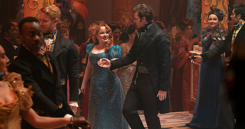 Nicola Coughlan as Penelope Featherington and Luke Newton as Colin Bridgerton dance together at a ball in Season 3 of 'Bridgerton'