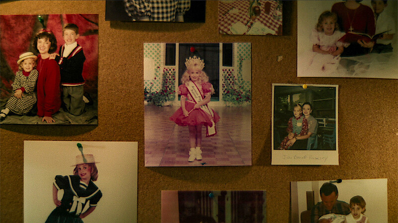 A cork board is filled with photos of JonBenét Ramsey and her family.