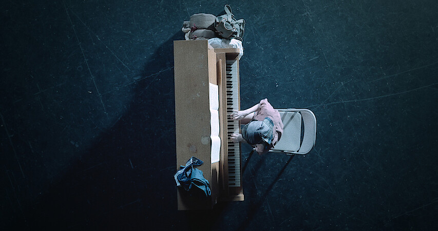 An overhead view of a girl playing a piano.