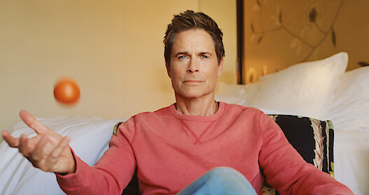 Actor Rob Lowe juggles an orange. 