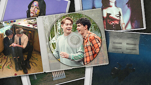 Kit Connor as Nick and Joe Locke as Charlie smile together on a CD cover, surrounded by album artwork from songs in Season 3 of 'Heartstopper'