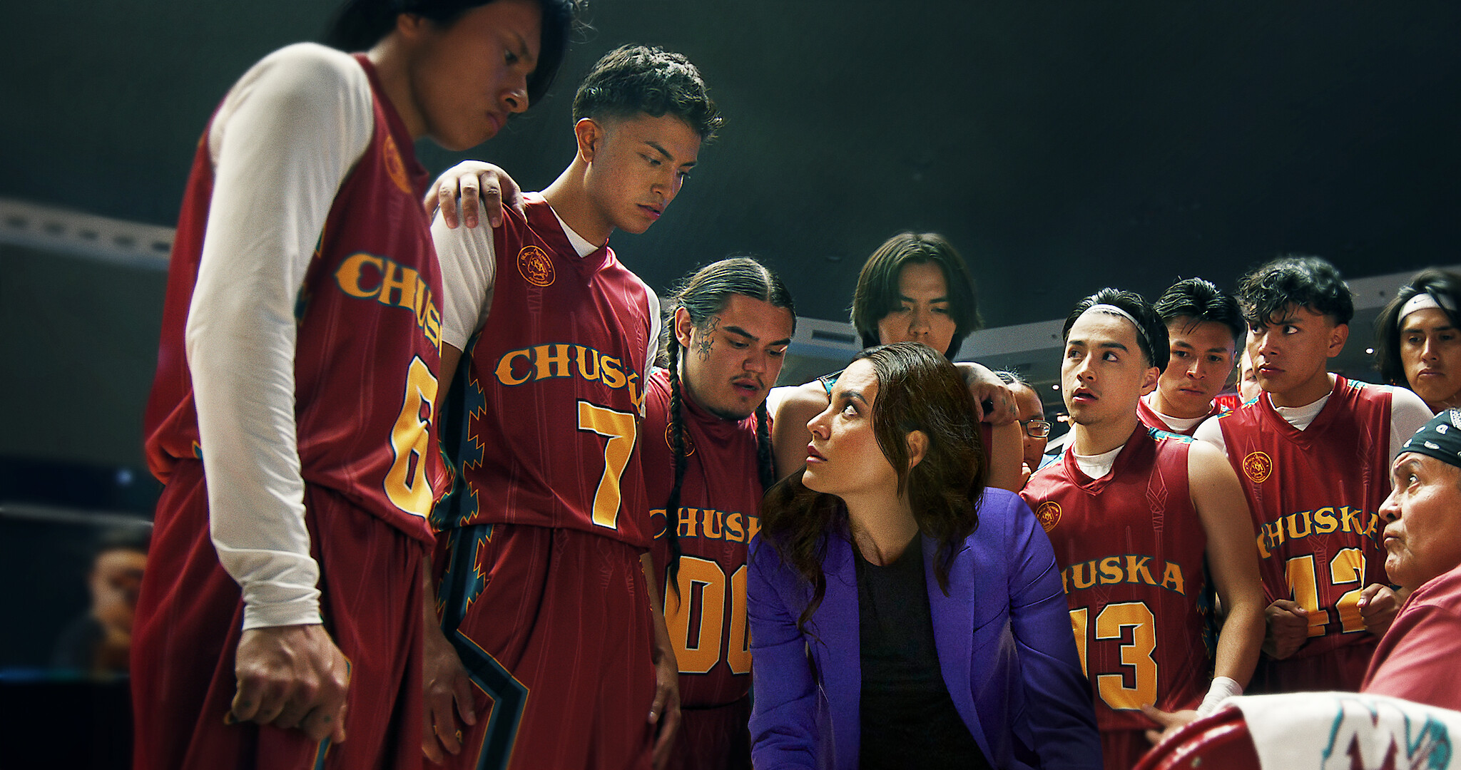 The characters of Rez Ball in a huddle around their coach during a game. 