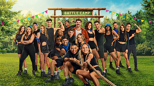 The cast of 'Battle Camp' Season 1 playing tug of war under a Battle Camp sign.