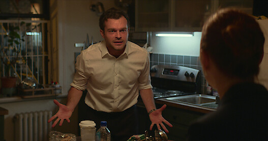  Alden Ehrenreich as Luke and Phoebe Dynevor as Emily argue in the kitchen.