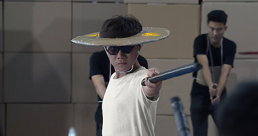 Man with fake sword fighting in behind-the-scenes footage of 'Blue Eye Samurai.'