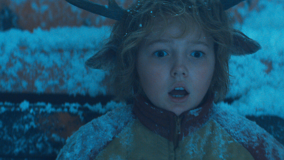 Christian Convery as Gus sits covered in snow with a surprised expression in season 3 of 'Sweet Tooth'