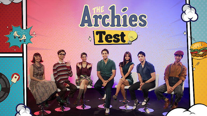 The cast of 'The Archies' seated on a stage together