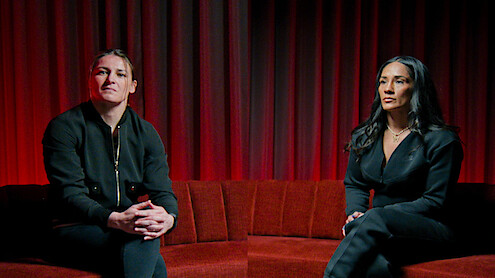 Katie Taylor and Amanda Serrano sitting on a red velvet couch
